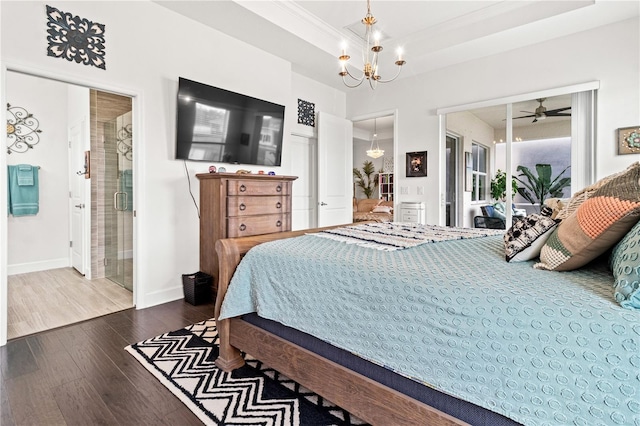 bedroom with hardwood / wood-style floors, a raised ceiling, ornamental molding, a notable chandelier, and ensuite bathroom