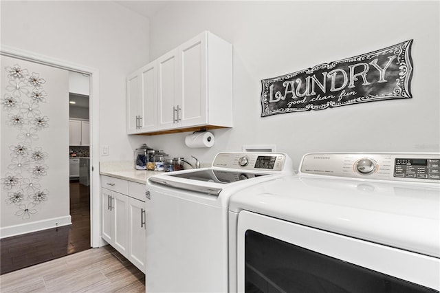 laundry area with cabinets and washing machine and clothes dryer