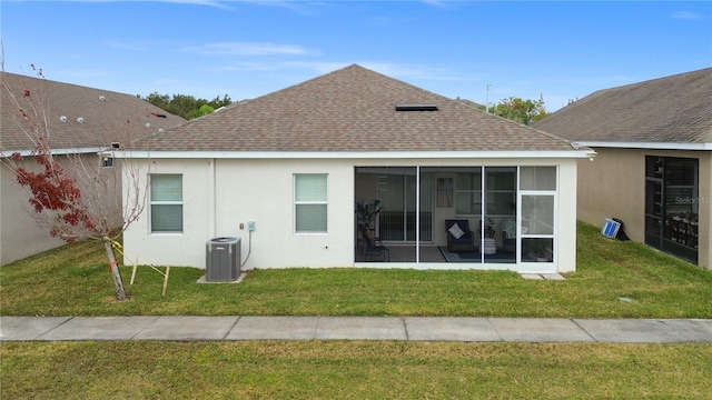 rear view of property with central AC, a yard, and a sunroom