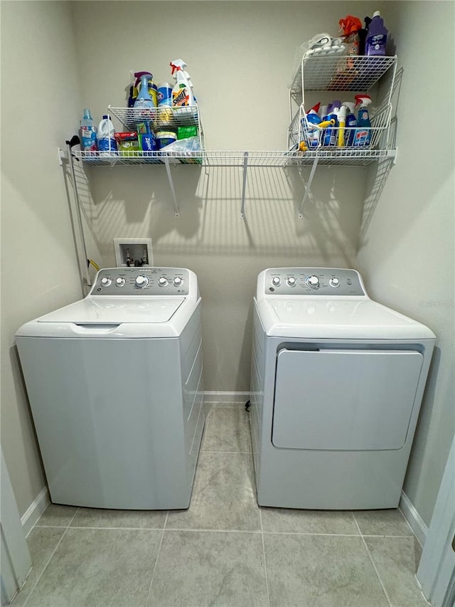 clothes washing area featuring washer and dryer and light tile patterned floors