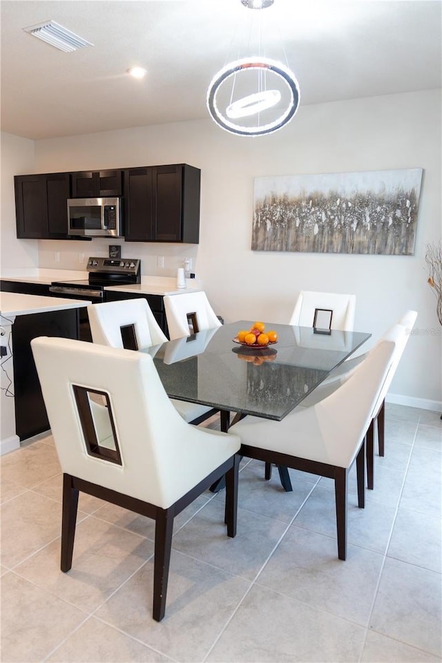 dining room with light tile patterned flooring and a notable chandelier