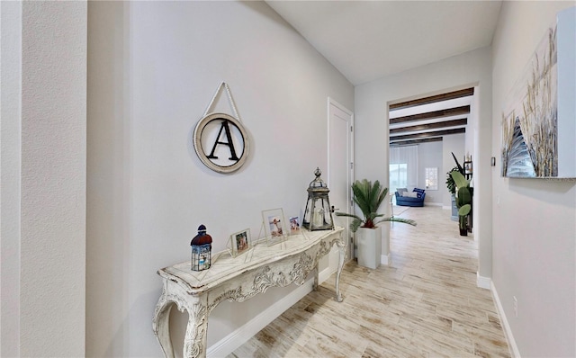 hall featuring light hardwood / wood-style flooring and beamed ceiling