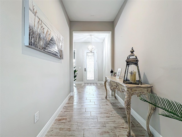 doorway to outside with an inviting chandelier