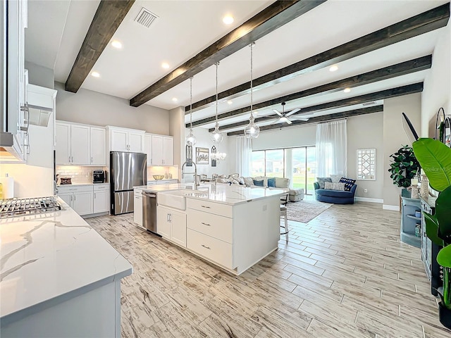 kitchen featuring stainless steel appliances, white cabinetry, and a spacious island