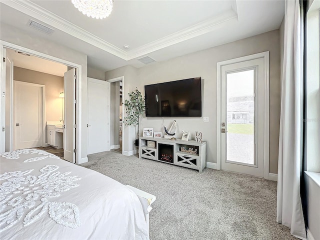 carpeted bedroom with connected bathroom, a tray ceiling, crown molding, and a notable chandelier