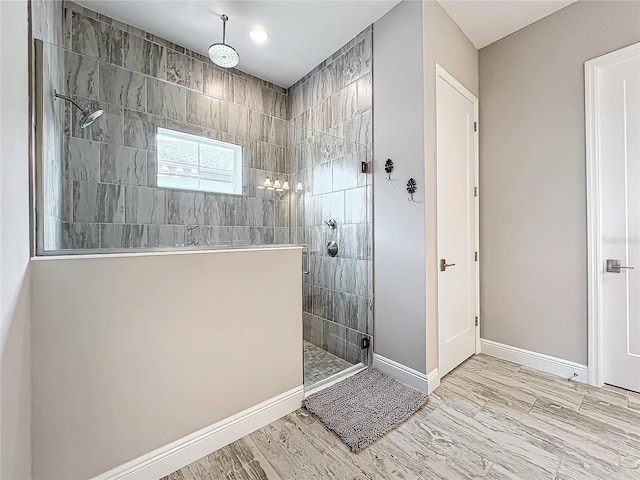 bathroom featuring hardwood / wood-style flooring and tiled shower