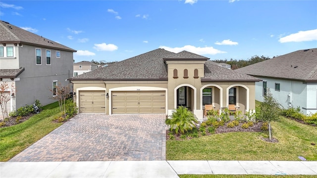 view of front of home featuring covered porch, a front lawn, and a garage