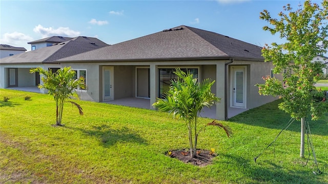 13028 Homestead Ln, Parrish, FL 34219 - back of property featuring stucco siding, a patio area, a lawn, and a shingled roof