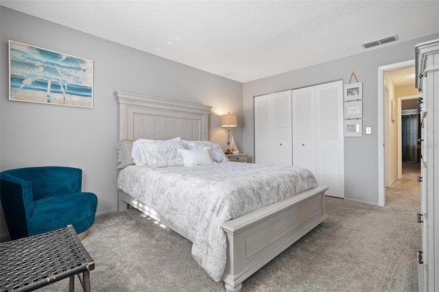 carpeted bedroom featuring a textured ceiling and a closet