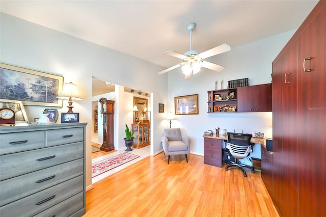 home office featuring light wood-style flooring, baseboards, ceiling fan, and vaulted ceiling