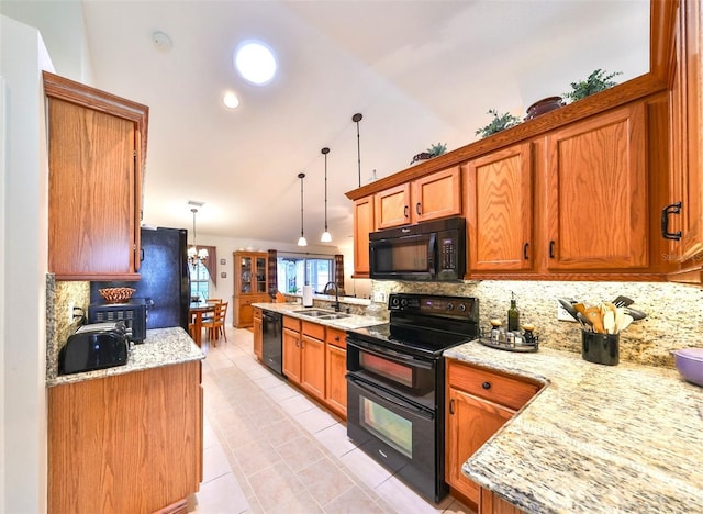 kitchen featuring brown cabinetry, black appliances, tasteful backsplash, and a sink