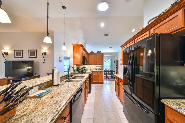 kitchen featuring brown cabinetry, light tile patterned flooring, a sink, black appliances, and backsplash