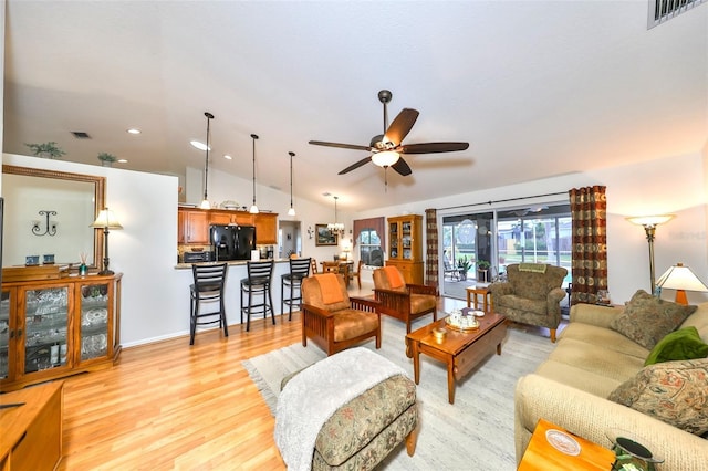 living room featuring light wood-style floors, vaulted ceiling, a ceiling fan, and visible vents