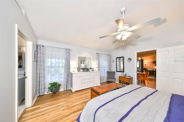 bedroom featuring a ceiling fan, lofted ceiling, and light wood-style floors