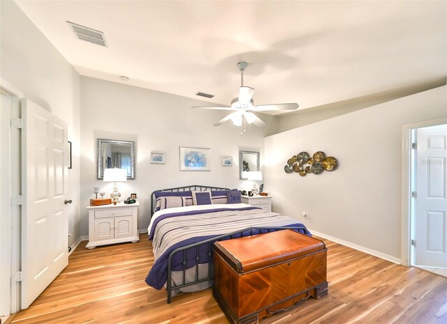 bedroom with baseboards, visible vents, and light wood finished floors