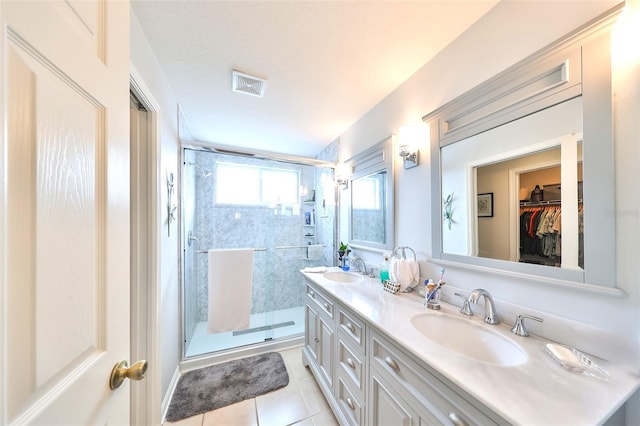 full bathroom with a sink, visible vents, double vanity, and a shower stall