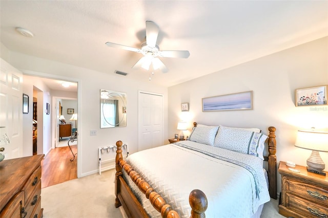 bedroom featuring visible vents, ceiling fan, baseboards, light carpet, and a closet