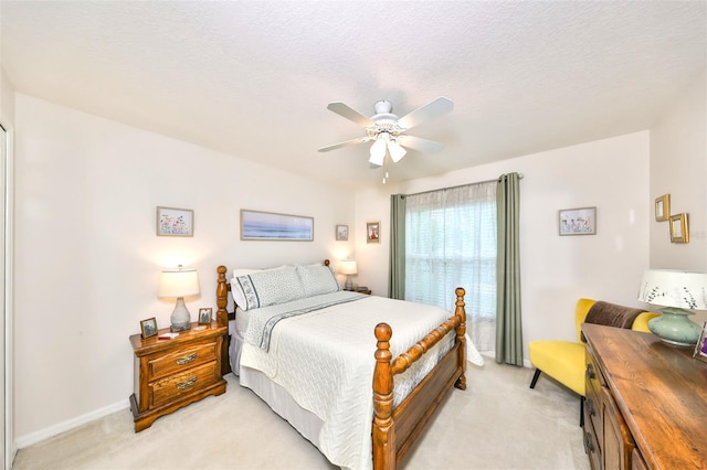 bedroom featuring a ceiling fan, light colored carpet, and baseboards