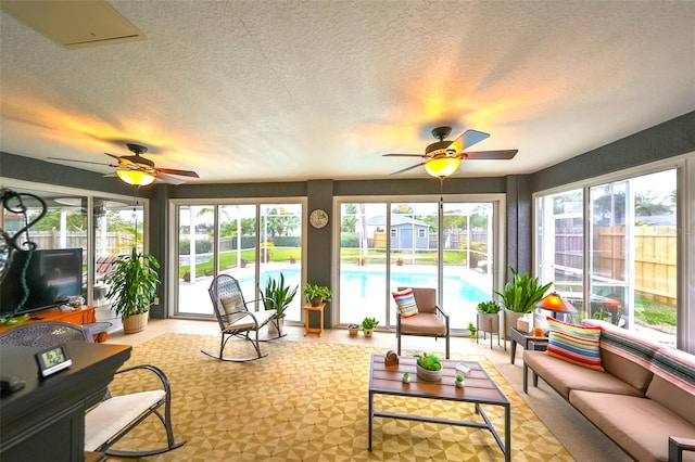 sunroom / solarium featuring a ceiling fan