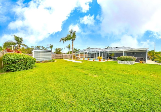 view of yard with glass enclosure and a fenced backyard