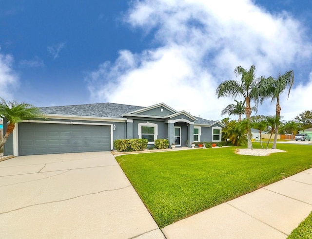 ranch-style house featuring a garage, stucco siding, driveway, and a front lawn