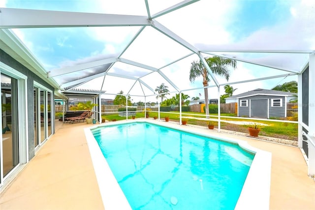 view of swimming pool with fence, a lawn, an outdoor structure, a patio area, and a storage unit