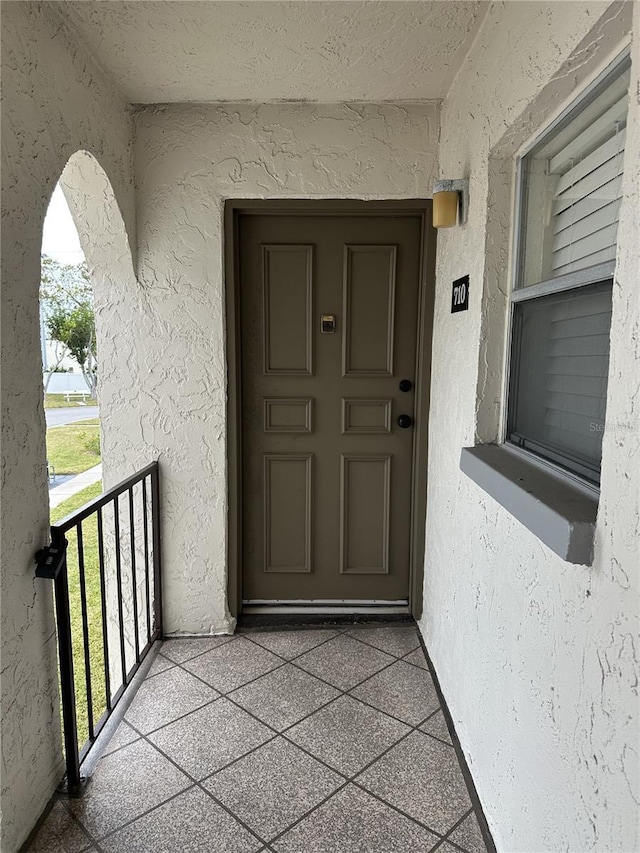 view of exterior entry featuring a balcony