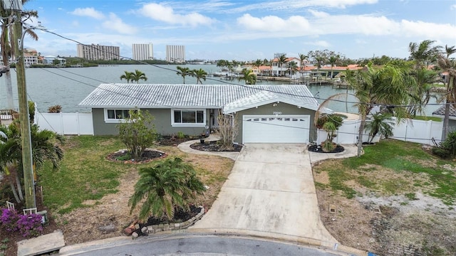 single story home featuring a garage, a front lawn, and a water view