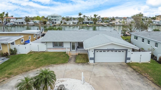 view of front of property featuring a garage, a water view, and a front lawn