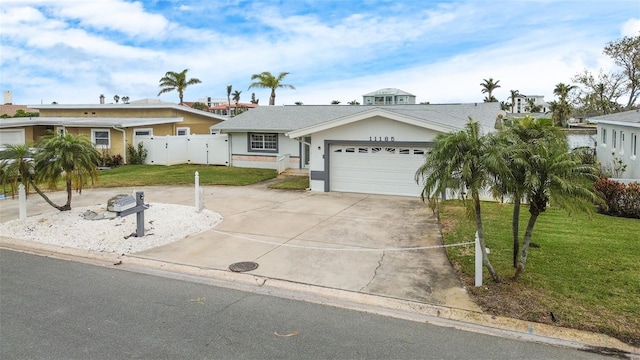 ranch-style house featuring a garage and a front lawn