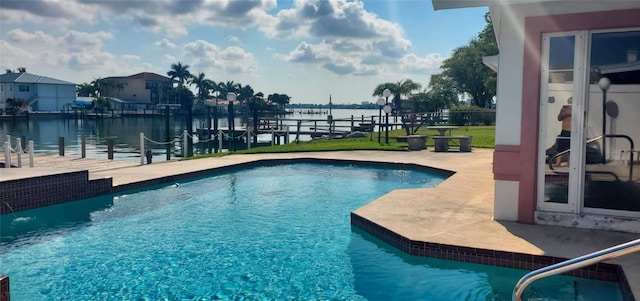 view of pool with a patio and a water view