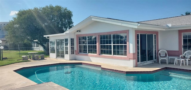 view of pool with a sunroom and a patio