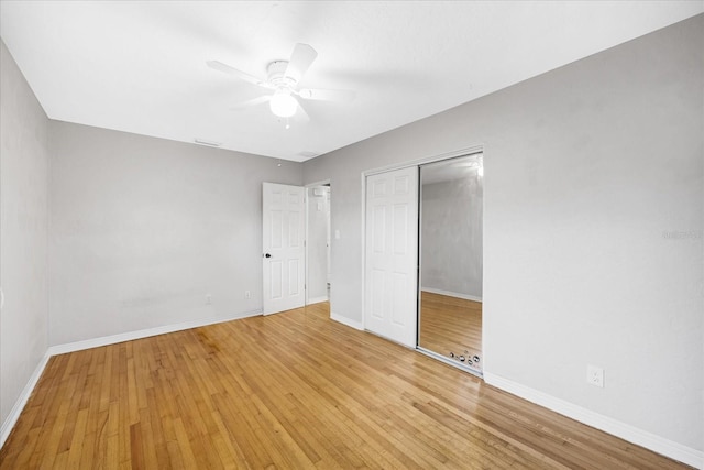 unfurnished bedroom with a closet, light hardwood / wood-style flooring, and ceiling fan