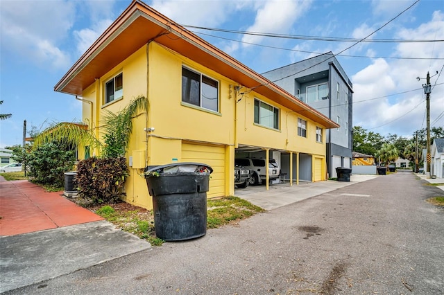 view of side of home featuring a garage and cooling unit