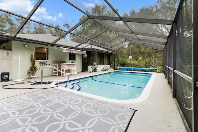 view of pool featuring glass enclosure and a patio area