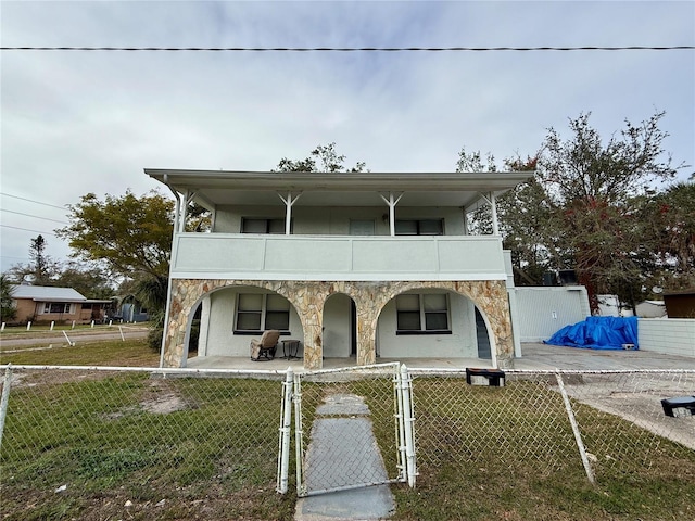 view of front facade featuring a front yard and a balcony