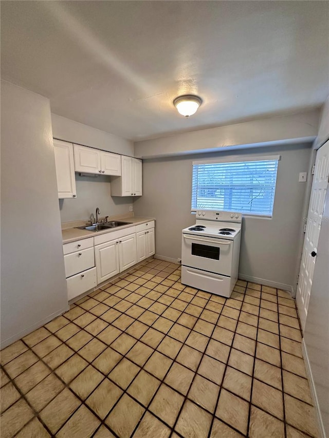 kitchen with electric stove, sink, and white cabinets