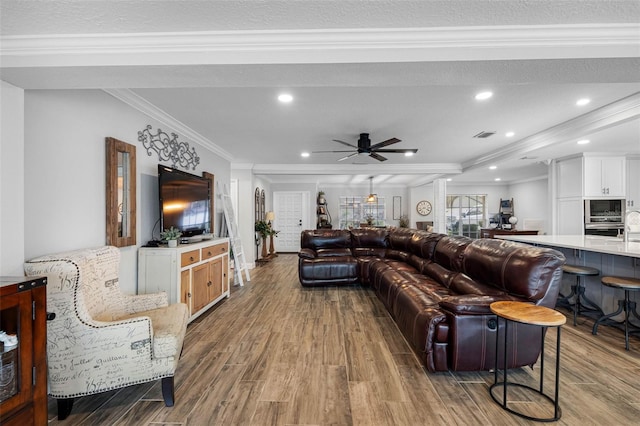 living room with ornamental molding, ceiling fan, and light hardwood / wood-style flooring