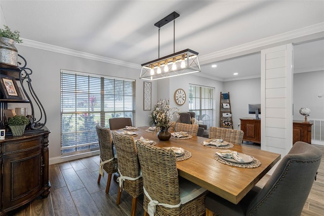 dining space featuring dark hardwood / wood-style flooring, a wealth of natural light, and crown molding