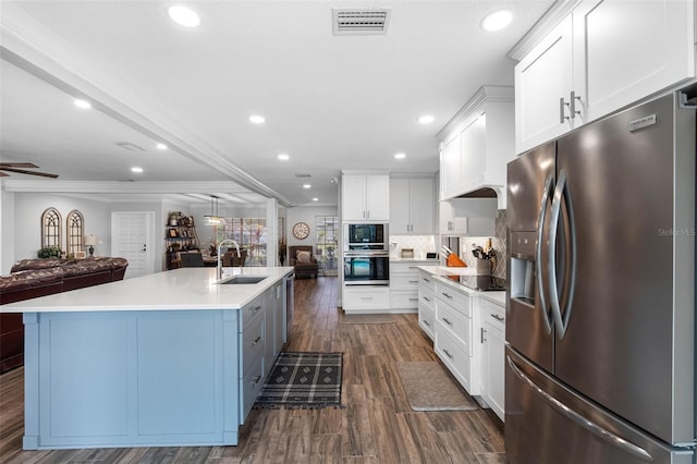 kitchen featuring sink, white cabinetry, tasteful backsplash, black appliances, and a kitchen island with sink