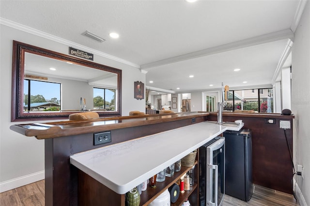 bar featuring ornamental molding, hardwood / wood-style floors, and wine cooler