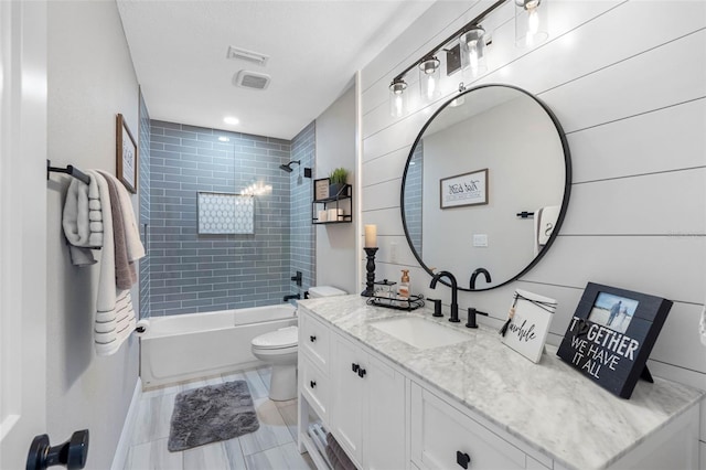 full bathroom featuring toilet, vanity, and tiled shower / bath