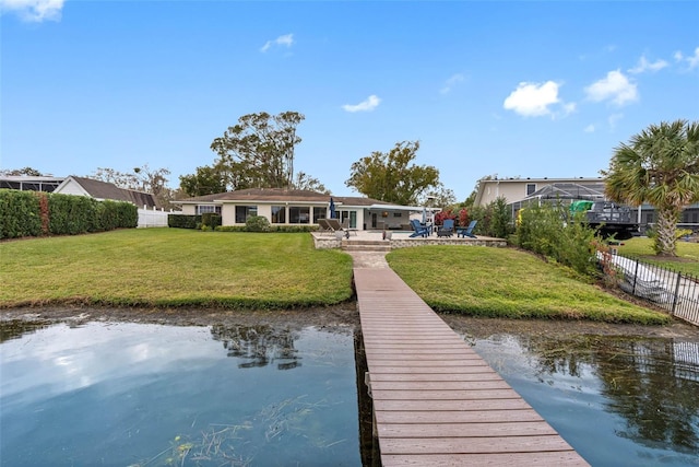 view of dock featuring a lanai, a yard, a water view, and a patio area