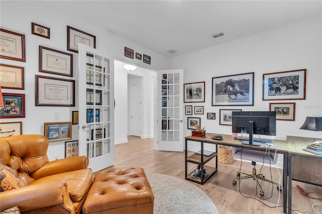 office area with light hardwood / wood-style floors and french doors