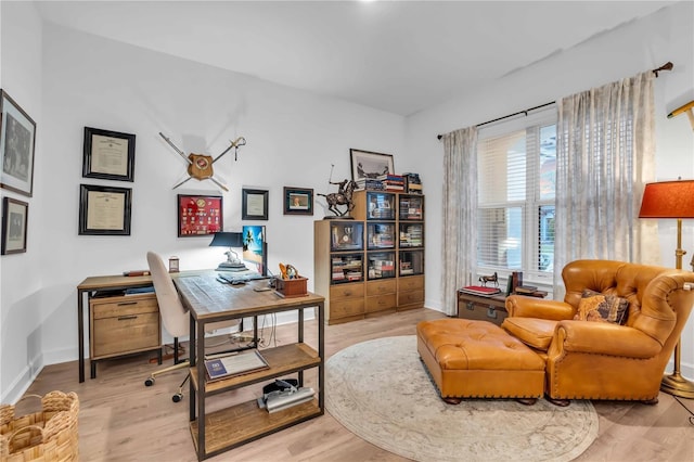 home office with light hardwood / wood-style floors