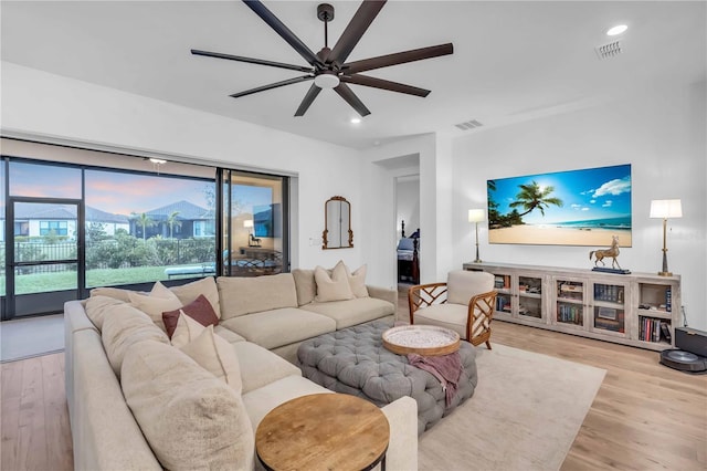 living room with light wood-type flooring and ceiling fan