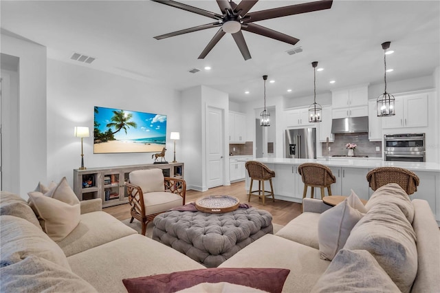 living room with ceiling fan and light hardwood / wood-style floors