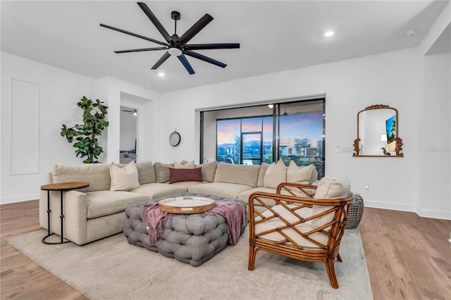 living room featuring ceiling fan and light hardwood / wood-style flooring