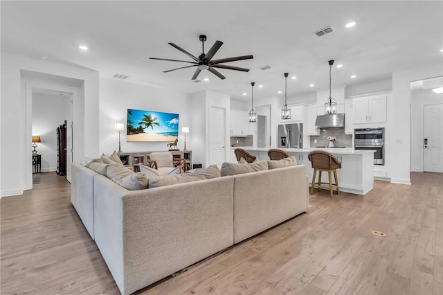 living room featuring light hardwood / wood-style floors and ceiling fan