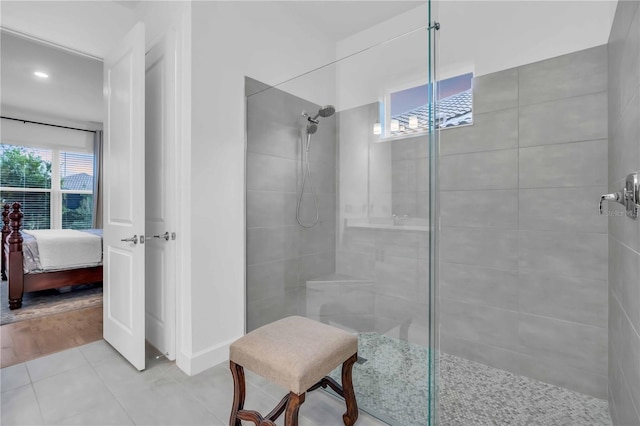 bathroom featuring tiled shower and tile patterned flooring